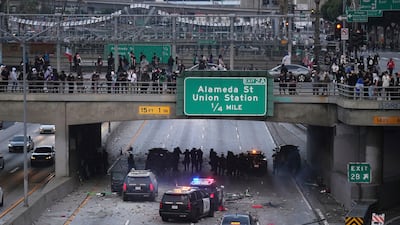 Protesters throw objects at California Highway Patrol vehicles on the 101 Freeway as officers take cover under the overpass. AP