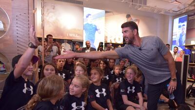 Former American swimmer Michael Phelps meets children at the opening of the Under Armour store at the Dubai Mall. Under Armour