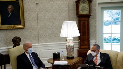 US President Joe Biden sits next to Senate Majority Leader Chuck Schumer as he meets Democratic senators in the Oval Office at the White House on February 3, 2021. Reuters