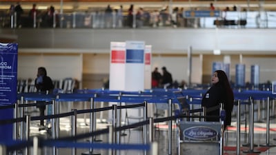 An airline worker stands in the empty international terminal at LAX airport in Los Angeles, California, US, March 11, 2020. Reuters