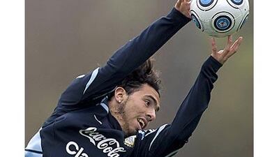 Argentina's striker Carlos Tevez reaches out to catch a ball during training in Buenos Aires. Strikers like him and Lionel Messi are at a slight disadvantage with their heights.