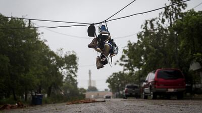 Shoes tied to a power line hang near a street after winds from Hurricane Harvey brought down a power pole in Corpus Christi, Texas. Nick Wagner / Austin American-Statesman via AP