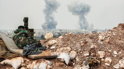 A Syrian forces' artillery observer looks through a scope as smoke plumes rise on the horizon during fighting with rebels near the town of Qumhanah in Hama province on April 1, 2017. AFP