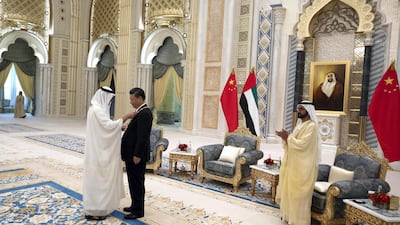 ABU DHABI, UNITED ARAB EMIRATES - July 20, 2018: HH Sheikh Mohamed bin Zayed Al Nahyan Crown Prince of Abu Dhabi Deputy Supreme Commander of the UAE Armed Forces (L) and HH Sheikh Mohamed bin Rashid Al Maktoum, Vice-President, Prime Minister of the UAE, Ruler of Dubai and Minister of Defence (R), present a Zayed Medal to HE Xi Jinping, President of China (2nd L), during a reception at the Presidential Palace. ( Hamad Al Kaabi / Crown Prince Court - Abu Dhabi ) ---