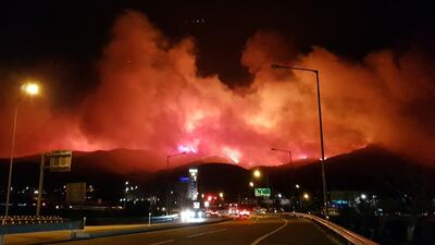 A view of fire which broke out a day earlier strikes mountains of Gangneung. Yonhap / EPA