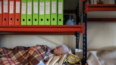 A Greek woman sleeps on a shelf after her home in Palamas was flooded during Storm Daniel on Saturday.