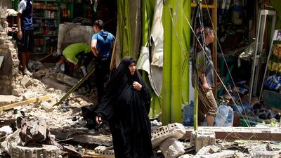 Civilians inspect the scene of a car bomb attack at the Al-Ameen neighborhood in Baghdad, Iraq. Karim Kadim / AP Photo