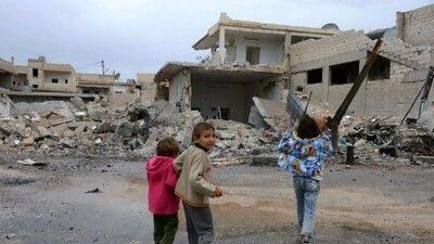 Syria's opposition factions are close to hammering out a deal to form a unified council. In the northern Syrian town of Taftanaz, children walk past buildings destroyed by an air strike. About 11,000 Syrians fled the country to neighbouring countries on Friday.
