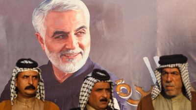 Iraqi tribal sheikhs stand next to the portraits of Iranian Revolutionary Guards commander Qasem Soleimani during a demonstration in Baghdad's western Shoala neighbourhood. AFP