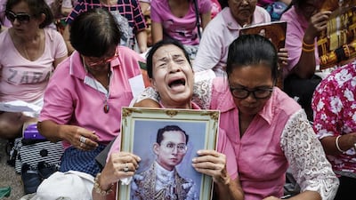 A Thai well-wisher weeps as she is comforted by others during a prayer for Thai King Bhumibol Adulyadej who died on October 13, 2016. The monarch is widely revered in Thailand. Rungroj Yongrit/EPA