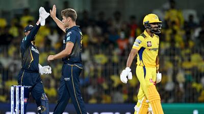 Gujarat Titans' Spencer Johnson, center, celebrates with wicketkeeper Wriddhiman Saha after taking the wicket of Chennai Super Kings captain Ruturaj Gaikwad. AFP