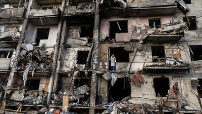Ukrainians clean up debris after a residential building was hit by Russian missiles in southern Kyiv, in February 2022.