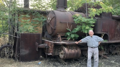 Assad Namroud, 92, is Lebanon's last living train driver. Here he is posing next to a rusting steam train in Riyaq. Photo by Maghie Ghali