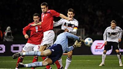 England's David James palms the ball away from the path of Germany's Miroslav Klose.