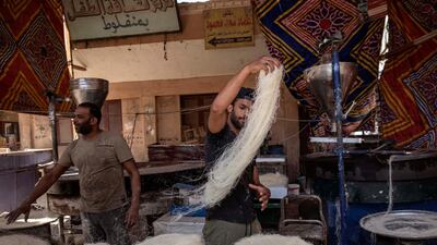 28-year-old football defender Mahrous Mahmoud, right, makes Ramadan sweets, in Manfalut, a town 350 kilometres south of Cairo in the province of Assiut, Egypt. AP Photo