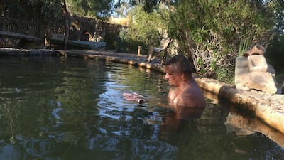 A man bathes in a natural hot water spring which is full of minerals.