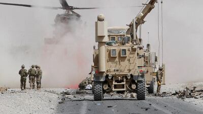 U.S. troops assess the damage to an armoured vehicle of NATO-led military coalition after a suicide attack in Kandahar province, Afghanistan.REUTERS