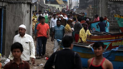 Indian fishermen gather to see the waves as others move fishing boat to a safer place near the Arabian sea coast, as Cyclone Vayu approaches Veraval, India. EPA