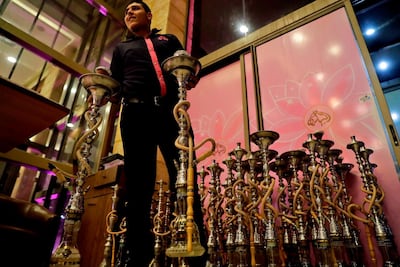 Waiters carry waterpipes to be served to clients at a restaurant in the coastal city of Byblos, north of Beirut, on May 22, 2019. AFP / JOSEPH EID