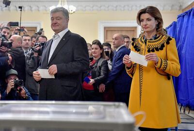 Ukrainian President Petro Poroshenko and his wife, Maryna, hold their ballot papers at a polling station. AFP