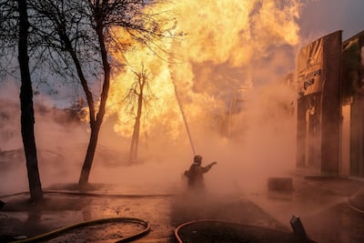 Firefighters work to extinguish flames after a missile strike in Kyiv. EPA