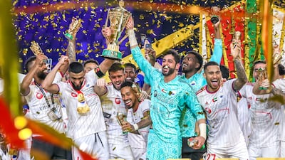 Sharjah players celebrate with the trophy after winning the President’s Cup. Victor Besa / The National