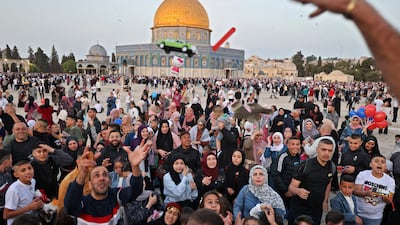 Muslims receive gifts in front of the Dome of the Rock mosque after the morning Eid al-Fitr prayer, which marks the end of the holy fasting month of Ramadan, at the Al-Aqsa mosques compound in Old Jerusalem. AFP