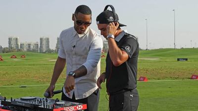 DJ Reggie Yates, left, gives Rickie Fowler some tips on mixing at a DJ booth at the Abu Dhabi Golf Club. Courtesy Four Communications