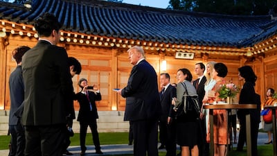 US President Donald Trump receives a copy of an album from members of the K-pop boy band Exo as he arrives for dinner at the Blue House in Seoul. Reuters