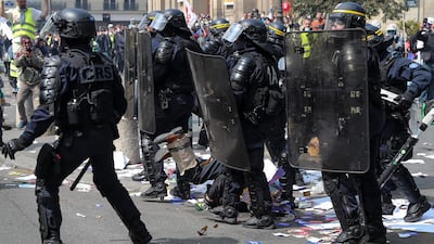A protester (C) falls on the ground as he is surrounded by riot police officers. AFP