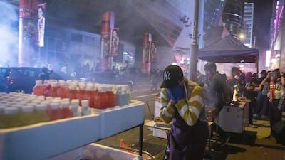 People react after riot police deploy tear gas at a Lunar New Year temporary night market on Portland Street during a protest in the Mong Kok district of Hong Kong, China. Bloomberg
