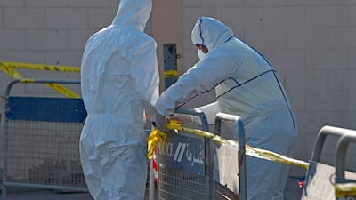 Bahraini policemen seal off a building housing foreign workers in the Salmabad industrial area as a precautionary measure after a resident tested positive for coronavirus, on the outskirts of the capital Manama. AFP