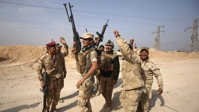 Iraqi forces celebrate recapturing the border town of Al Qaim from ISIL on November 4, 2017. Ahmad Al Rubaye / AFP