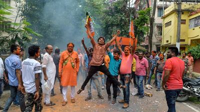 An Indian supporter of Bharatiya Janata Party (BJP) jumps in the air as he celebrates along with others on the vote results day. AFP