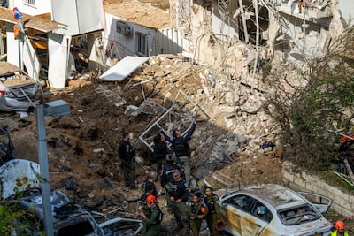 Rescuers gather near a crater left by an Iranian missile in Tel Aviv. Getty Images