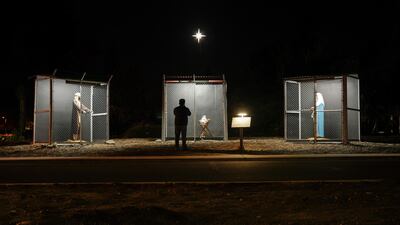 A US man view sculptures of Jesus, Mary and Joseph, depicted as refugees in cages, at a Nativity scene at Claremont United Methodist Church in California. Reuters