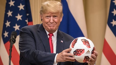 US President Donald Trump holds a World Cup football given to him by Russian President Vladimir Putin during a summit in Helsinki in 2018. Getty Images