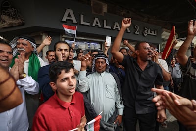 Iraqis chant outside the Central Bank of Iraq HQ in Baghdad, during a protest against the decision to devalue the dinar. AFP