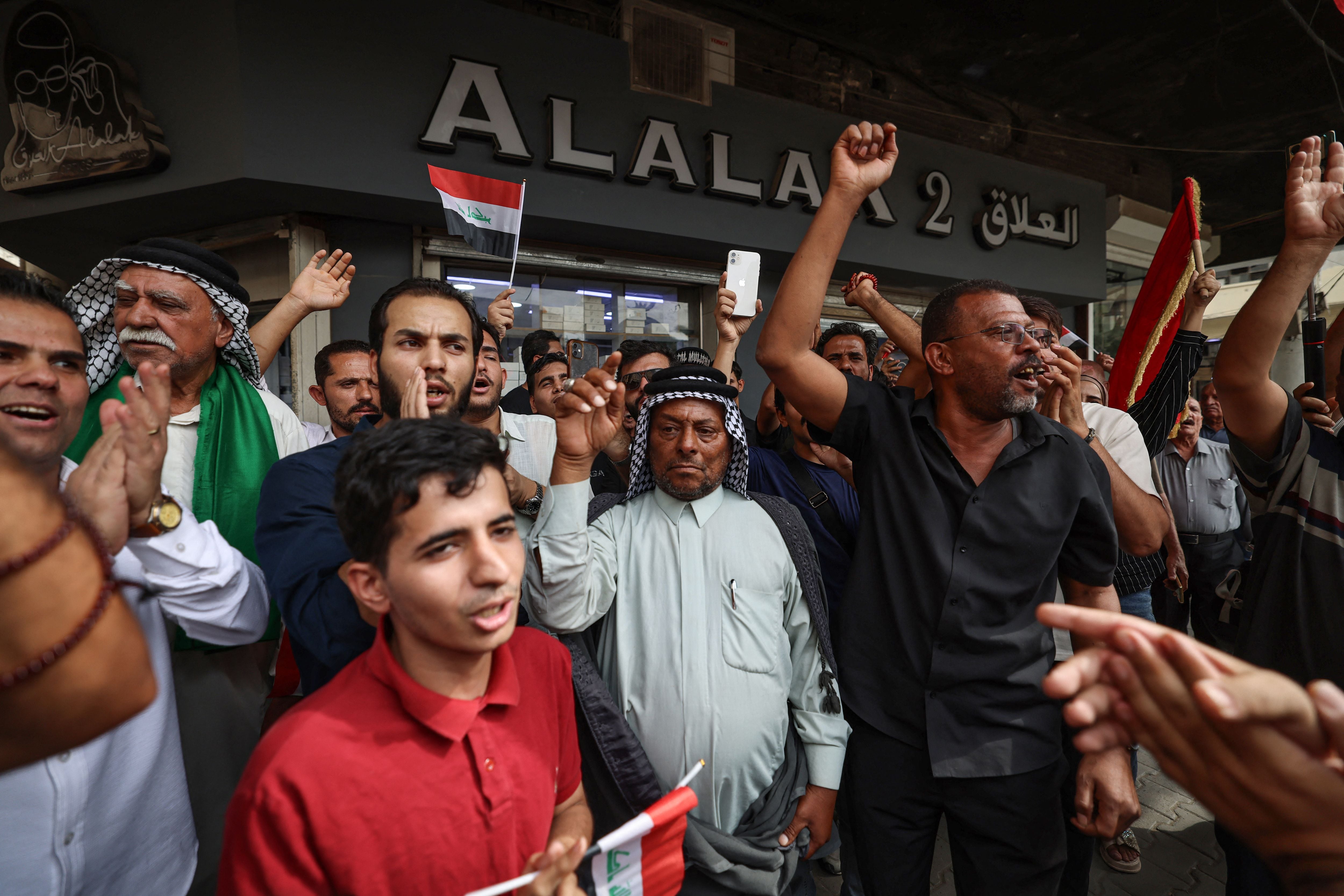 Iraqis chant outside the Central Bank of Iraq HQ in Baghdad, during a protest against the decision to devalue the dinar. AFP