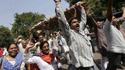 Protesters carry a mock dead body representing the Indian government while demonstrating against foreign direct investment in New Delhi.