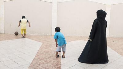 Fatima with Zayed, 7, and Saif, 6, as they play at their shared villa. Reem Mohammed / The National