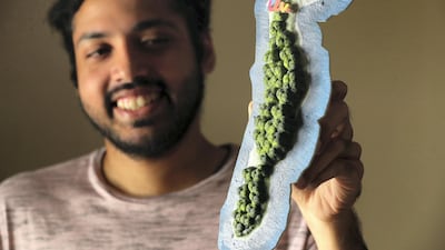 Brendan Lopez holds up a model of the private island off the coast of Canada that he won in a competition. Chris Whiteoak / The National