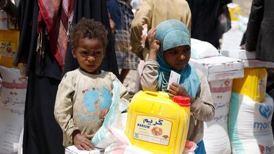 Displaced Yemeni children stand next to their family's share of emergency food aid provided by a local relief agency. EPA