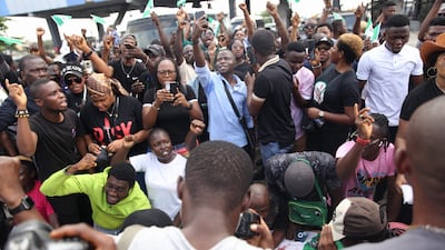 Protesters shout slogans on the road leading to the Lekki toll gate. EPA