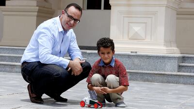 Ali Abdel Hafiz demonstrates the car kit with solar panels to his son, Ziad, at the American University of Sharjah. Pawan Singh / The National