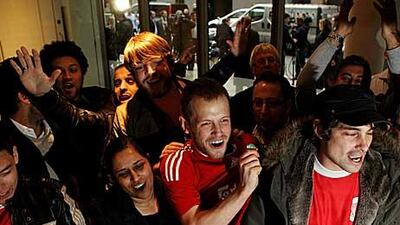 Liverpool fans celebrate in the offices of the law firm Slaughter and May after John W Henry announced his purchase of the club.