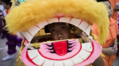 A young boy in a dragon costume parades among volunteers in Beijing after the announcement that Beijing had been named to host the 2022 Winter Olympic Games. Fred Dufour / AFP