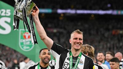 Newcastle defender Dan Burn celebrates with the League Cup trophy. AFP