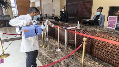Staff spray the lobby of a hotel in Ras Al Khaimah with disinfectant. Antonie Robertson / The National