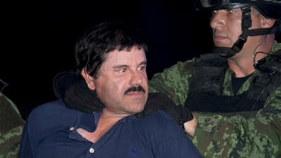 Mexican drug lord Joaquin 'El Chapo' Guzman is made to face the press as he is escorted to a helicopter in handcuffs by Mexican soldiers. AP Photo/Marco Ugarte